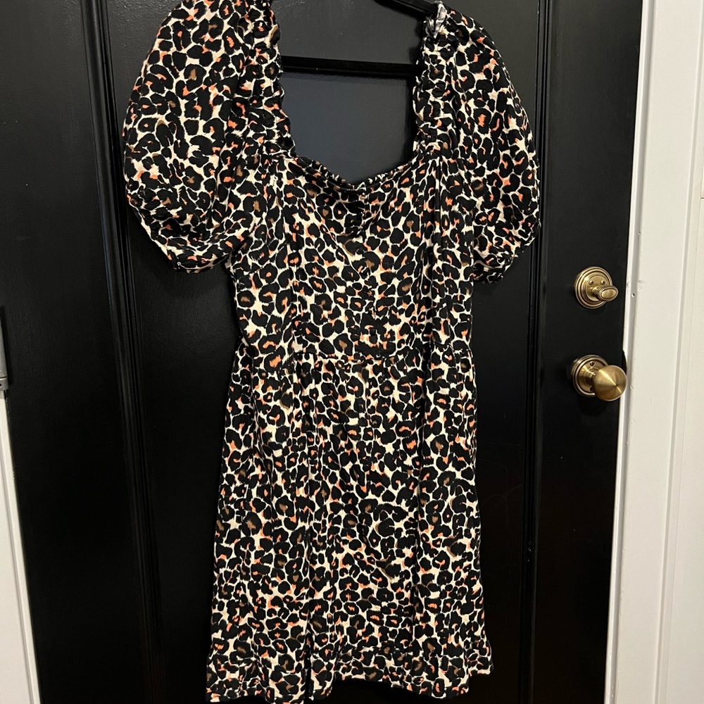 Leopard print dress with orange accents and button details.